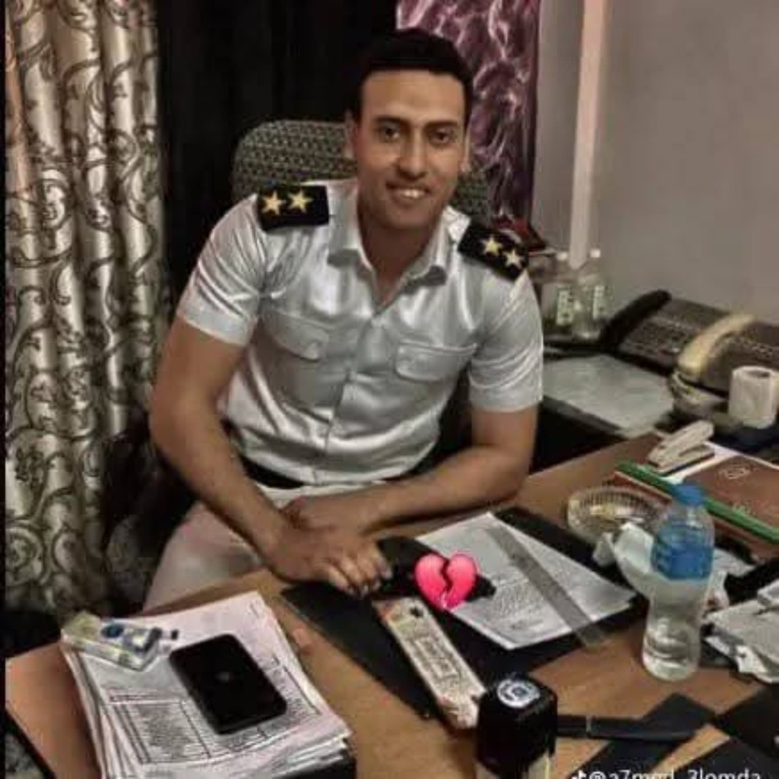 الشهيد محمود أحمد عبد الصبور سعد مرتديًا زي الشرطة أثناء جلوسه في مكتب